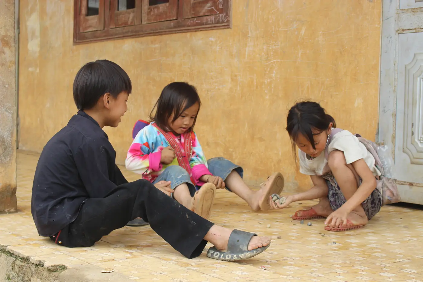 Các em nhỏ cùng chơi trước hiên nhà