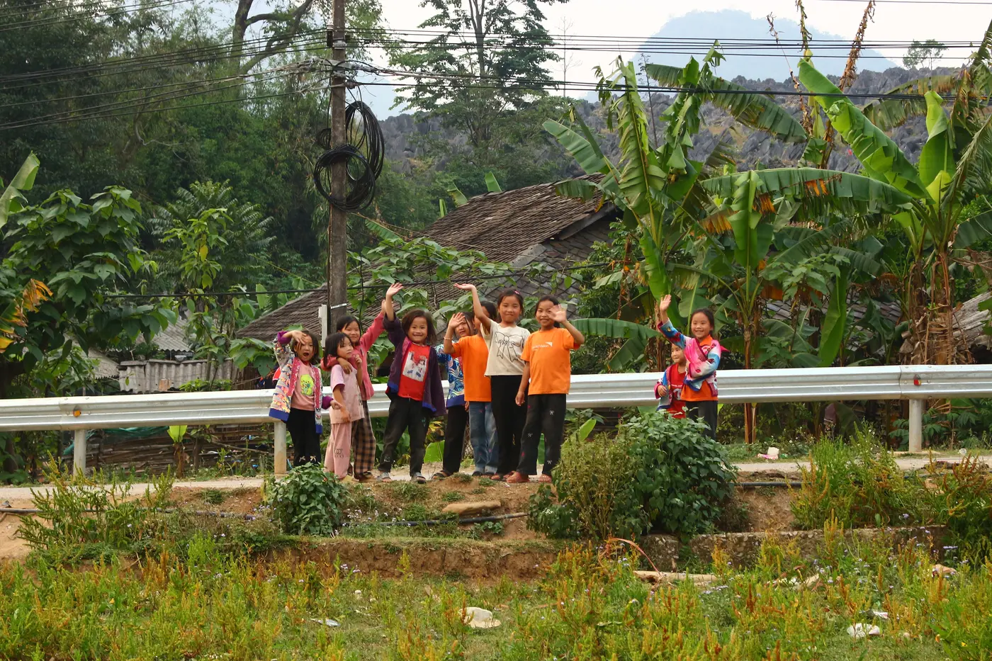Nhóm trẻ và tình nguyện viên bên đường bản